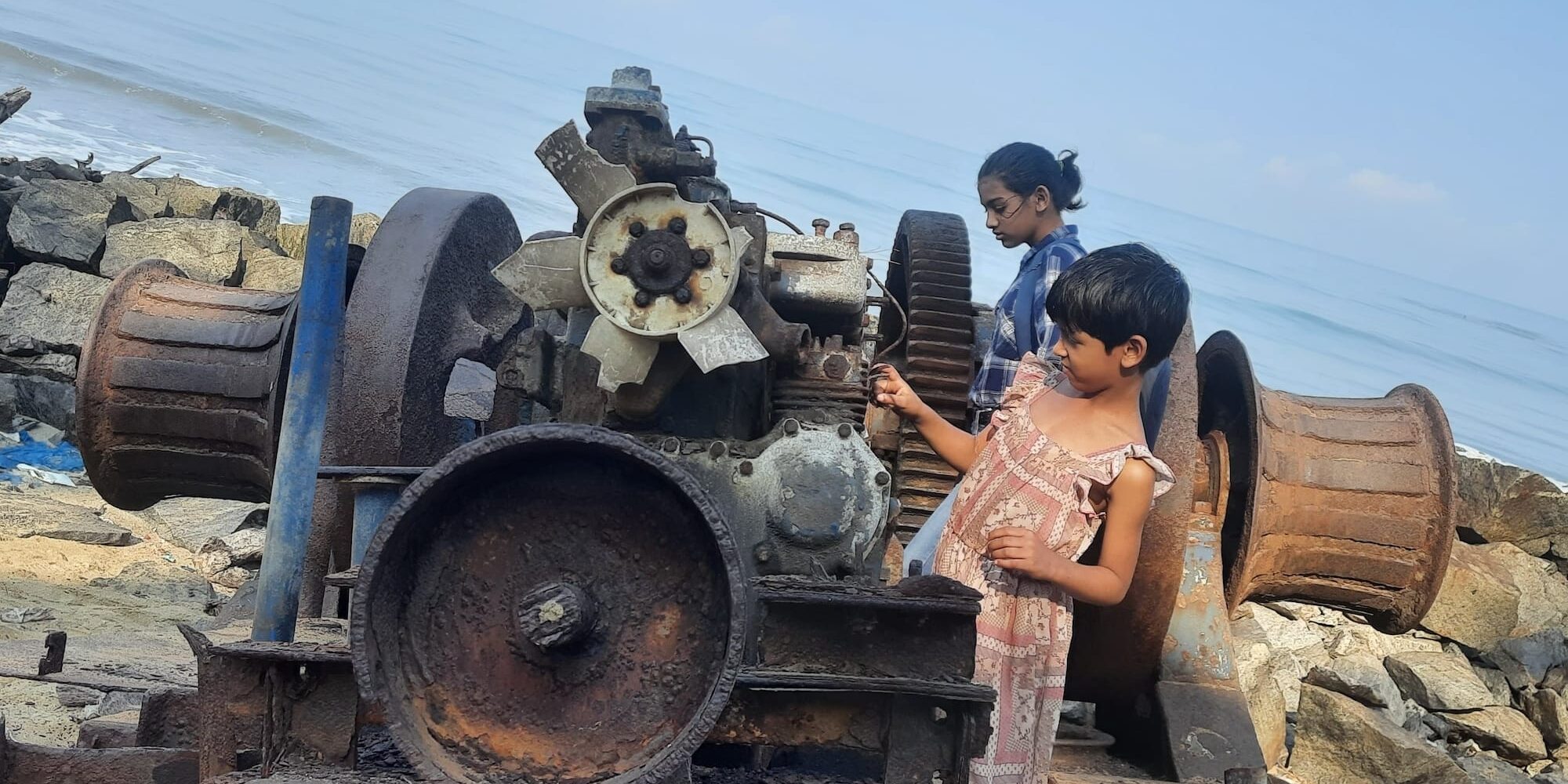 Hiranya and chinmayi exploring an old engine in the beach